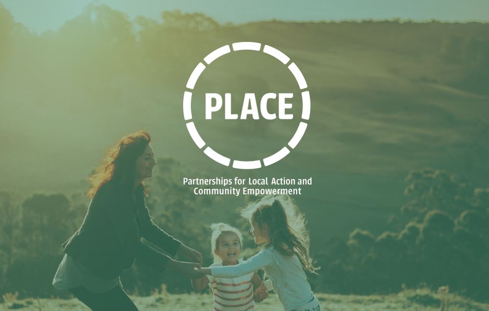 Woman holding hands with two children outdoors (with PLACE logo)